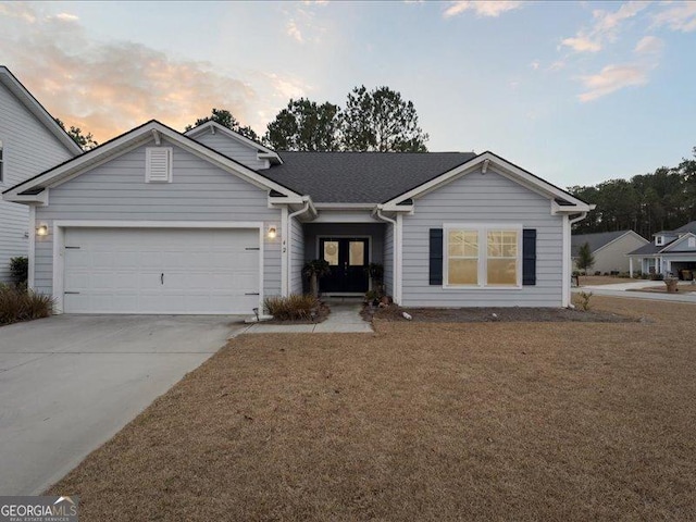 ranch-style house featuring a garage and a yard