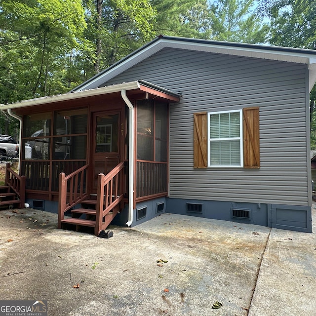 view of front facade with a patio area and a sunroom