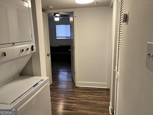 hall featuring stacked washer and dryer, dark hardwood / wood-style flooring, and a textured ceiling