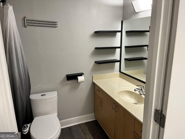 bathroom with vanity, toilet, and hardwood / wood-style floors