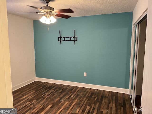 spare room with dark wood-type flooring and a textured ceiling