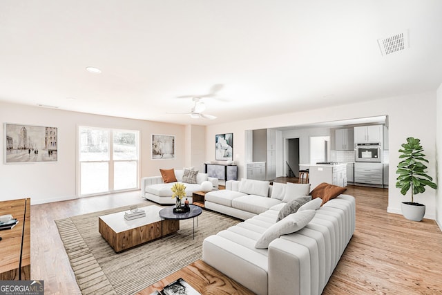 living room featuring ceiling fan and light hardwood / wood-style floors