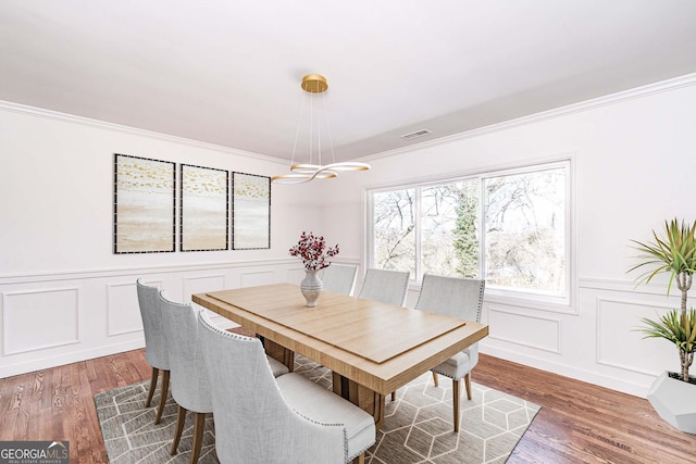 dining room with dark hardwood / wood-style flooring and ornamental molding