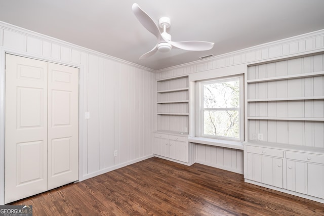 unfurnished bedroom with dark hardwood / wood-style flooring, ornamental molding, and ceiling fan