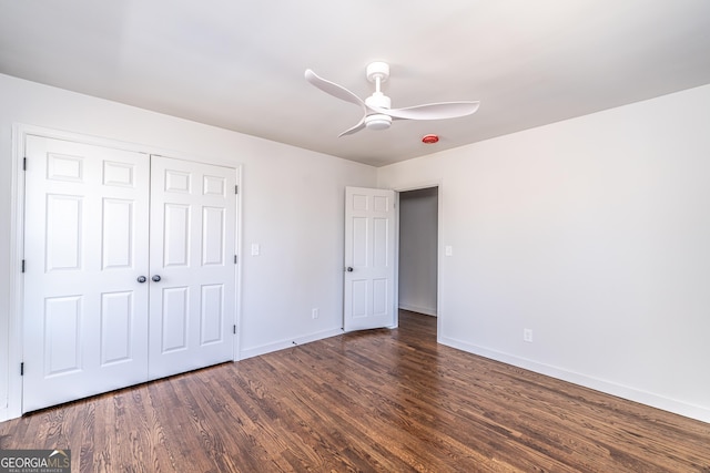 unfurnished bedroom with dark wood-type flooring, a closet, and ceiling fan