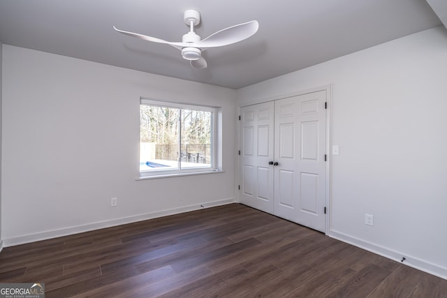 unfurnished bedroom featuring dark wood-type flooring, ceiling fan, and a closet