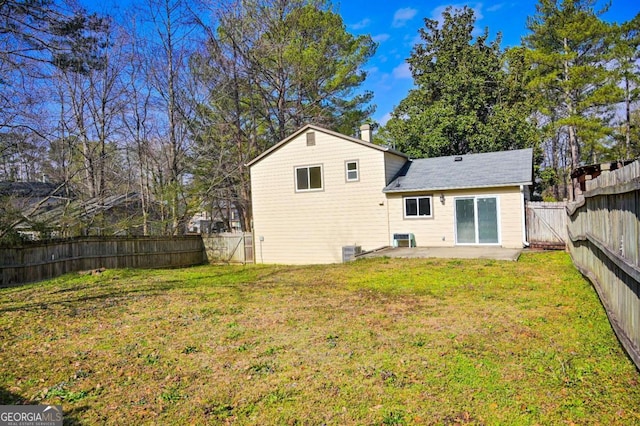 back of house with a yard and a patio