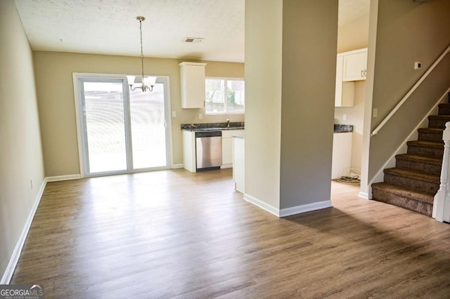 interior space with a wealth of natural light, sink, hardwood / wood-style floors, and a chandelier