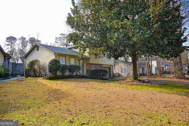 tri-level home featuring a garage and a front yard