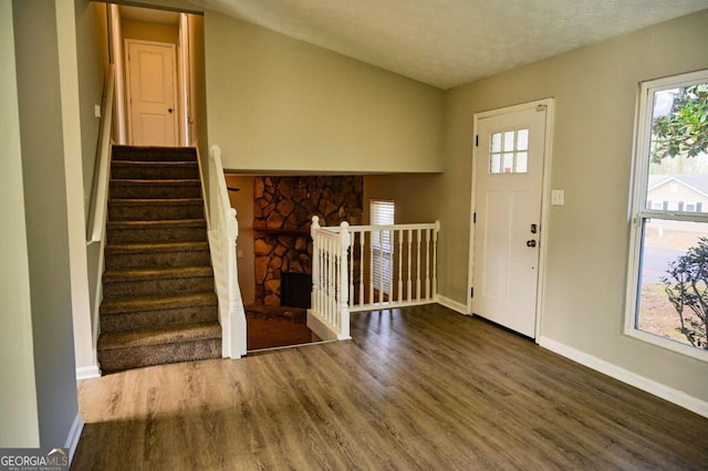 entryway featuring a fireplace and dark hardwood / wood-style flooring