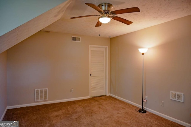 bonus room featuring ceiling fan, a textured ceiling, and carpet