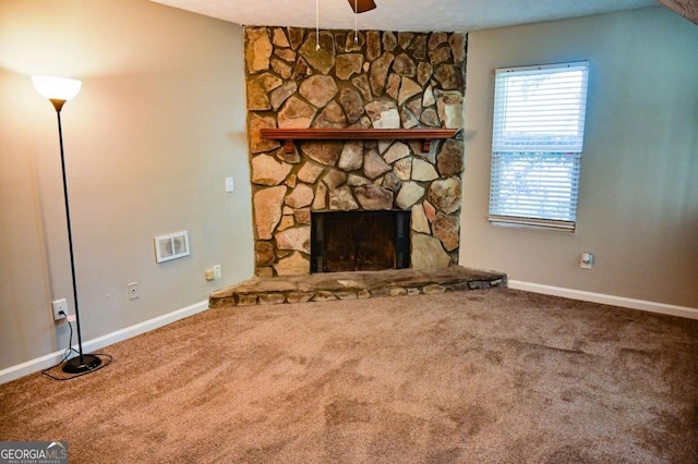 unfurnished living room featuring lofted ceiling, a fireplace, ceiling fan, and carpet flooring