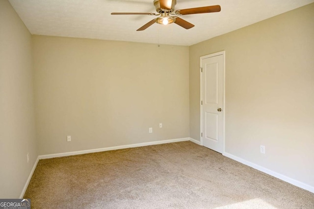 unfurnished room with ceiling fan and carpet