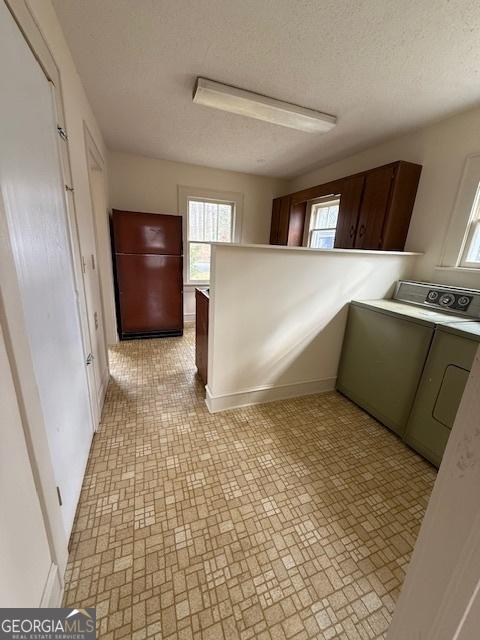 laundry room featuring washer / dryer and a textured ceiling