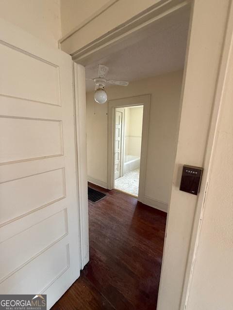 hallway with dark hardwood / wood-style flooring