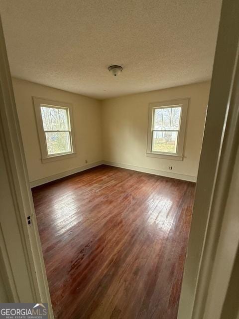 spare room with hardwood / wood-style flooring and a textured ceiling