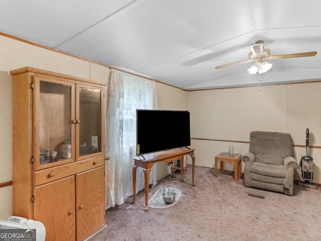 sitting room with lofted ceiling, crown molding, light colored carpet, and a textured ceiling