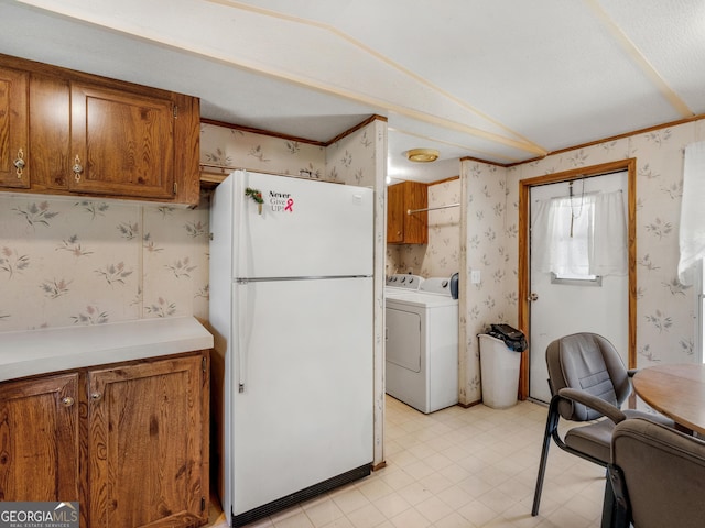 kitchen with crown molding, lofted ceiling, and white fridge