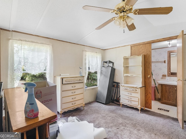 bedroom featuring connected bathroom, vaulted ceiling, a textured ceiling, ceiling fan, and carpet