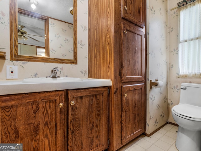 bathroom with tile patterned flooring, vanity, ceiling fan, and toilet