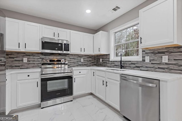 kitchen featuring white cabinetry, sink, tasteful backsplash, and stainless steel appliances