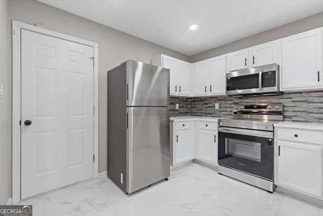 kitchen featuring white cabinetry, appliances with stainless steel finishes, and tasteful backsplash