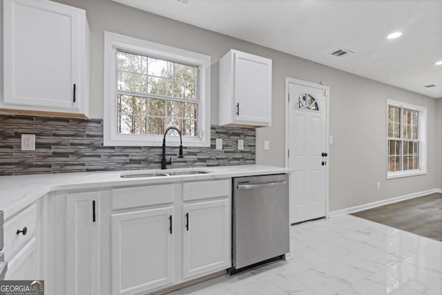 kitchen with white cabinetry, sink, backsplash, stainless steel dishwasher, and light stone countertops