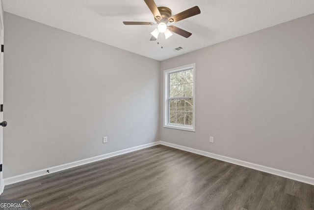 empty room with ceiling fan, dark hardwood / wood-style flooring, and a textured ceiling