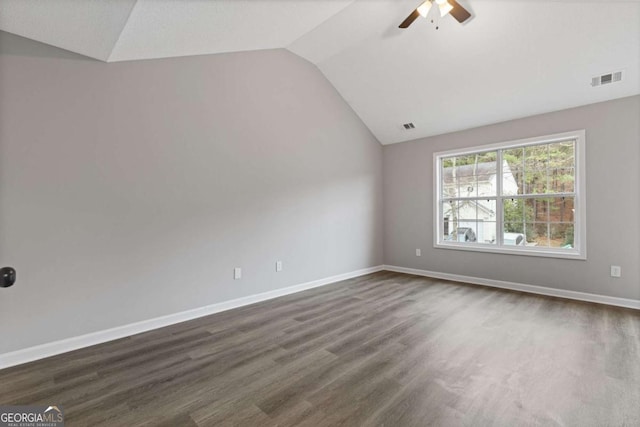 empty room featuring vaulted ceiling, dark wood-type flooring, and ceiling fan