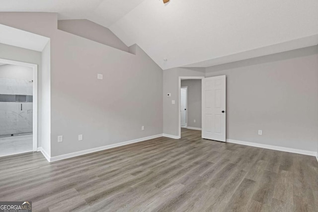 unfurnished room featuring vaulted ceiling and hardwood / wood-style floors