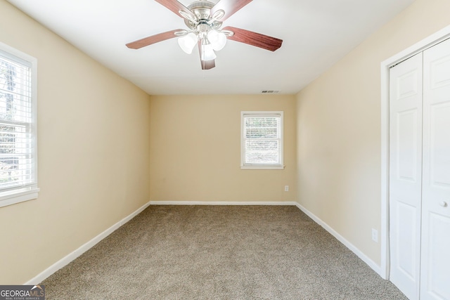 unfurnished bedroom featuring carpet flooring, ceiling fan, and a closet