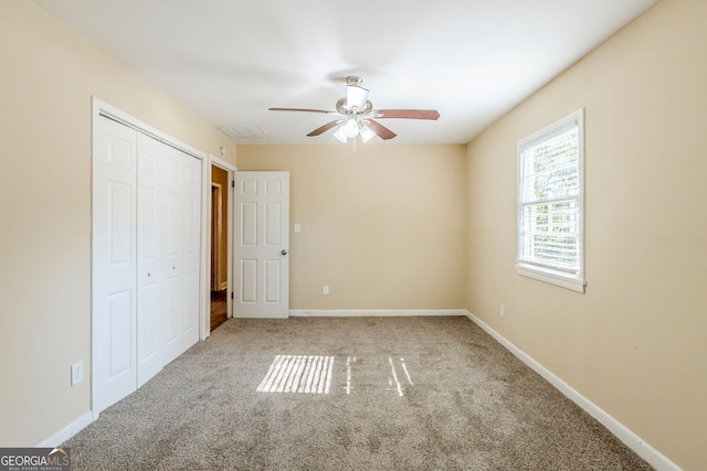 unfurnished bedroom featuring ceiling fan, carpet flooring, and a closet