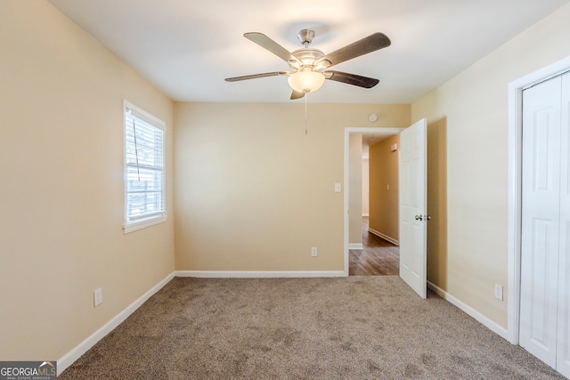 carpeted spare room featuring ceiling fan