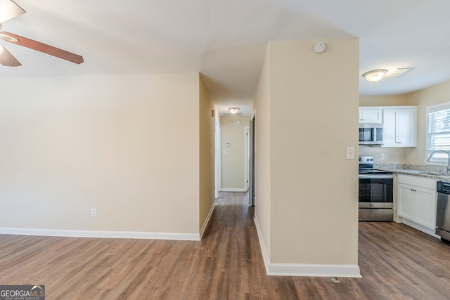 kitchen with wood-type flooring, sink, white cabinets, ceiling fan, and stainless steel appliances