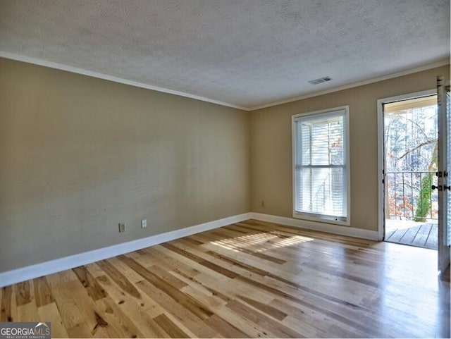 unfurnished room with light hardwood / wood-style flooring, ornamental molding, and a textured ceiling