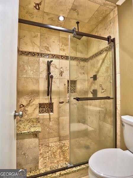 bathroom with toilet and walk in shower