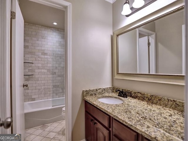 full bathroom with vanity, tile patterned flooring, toilet, and tiled shower / bath