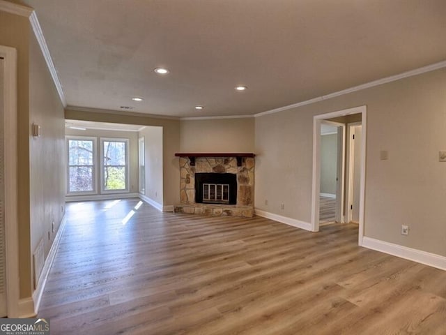 unfurnished living room featuring ornamental molding, a fireplace, and light hardwood / wood-style flooring