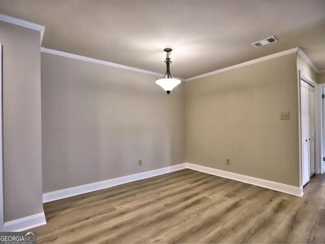 spare room with ornamental molding and dark hardwood / wood-style floors