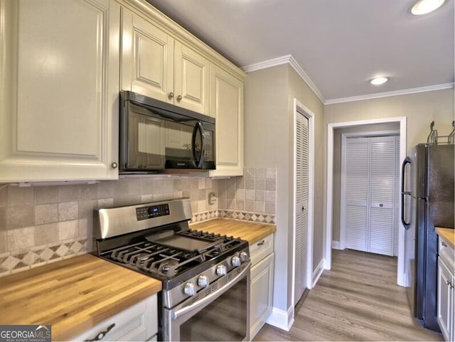 kitchen with tasteful backsplash, crown molding, butcher block countertops, and black appliances