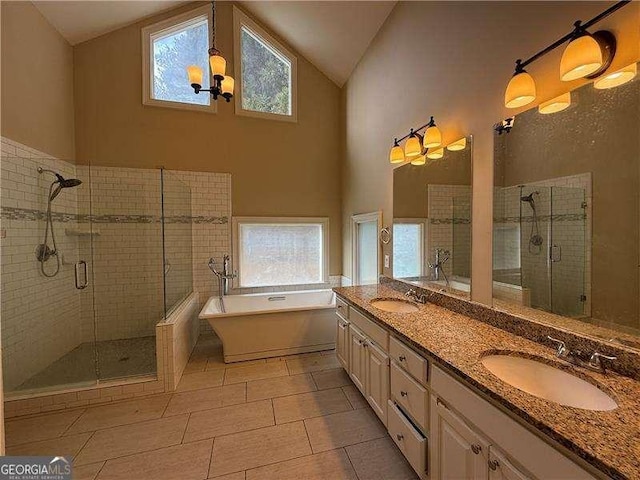 bathroom featuring tile patterned floors, a chandelier, separate shower and tub, high vaulted ceiling, and vanity