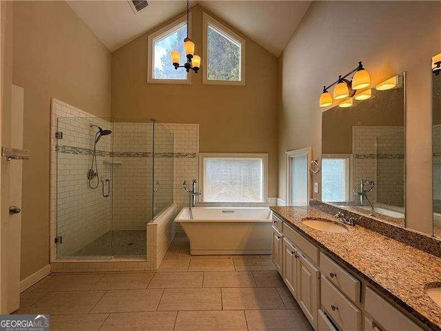 bathroom with tile patterned floors, shower with separate bathtub, high vaulted ceiling, vanity, and a notable chandelier