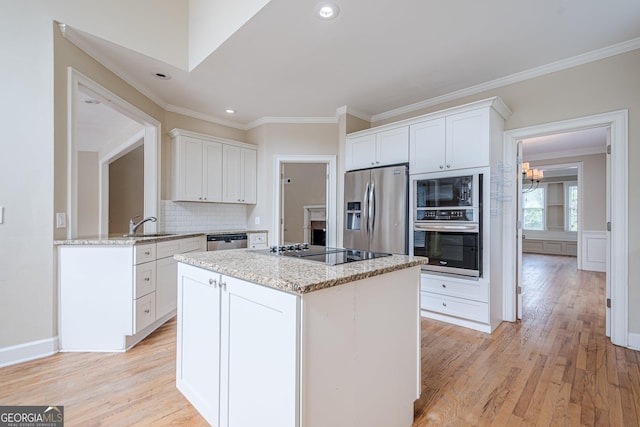 kitchen featuring light wood-style flooring, recessed lighting, a kitchen island, appliances with stainless steel finishes, and decorative backsplash