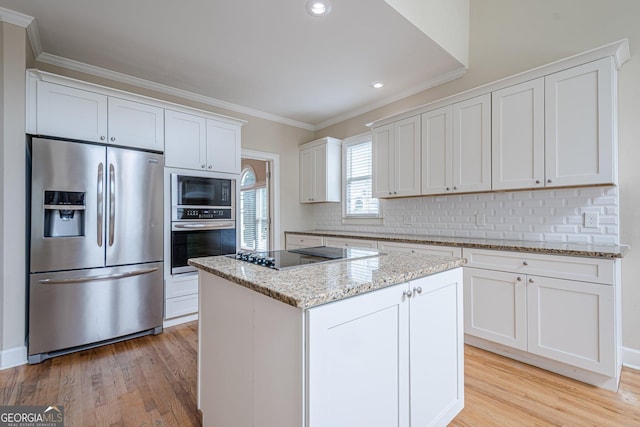 kitchen featuring tasteful backsplash, ornamental molding, light wood-style flooring, and black appliances