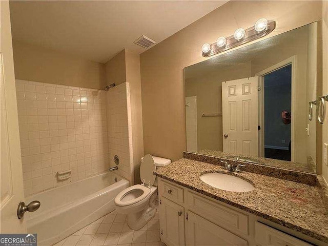 full bathroom featuring tile patterned flooring, vanity, tiled shower / bath combo, and toilet