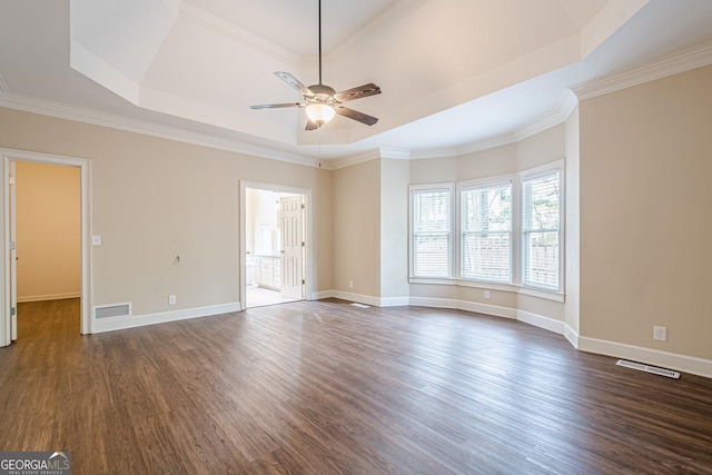 unfurnished room featuring dark wood-type flooring, visible vents, a raised ceiling, and a ceiling fan