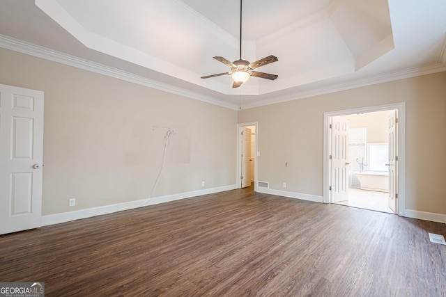 spare room featuring visible vents, a raised ceiling, a ceiling fan, dark wood-style floors, and crown molding