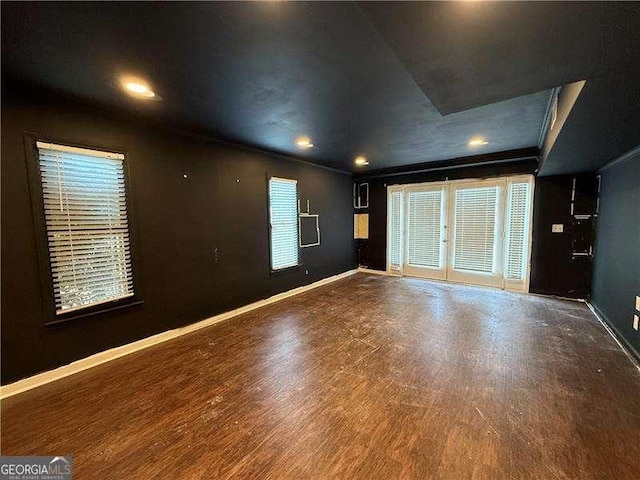 empty room with dark wood-type flooring, crown molding, and french doors