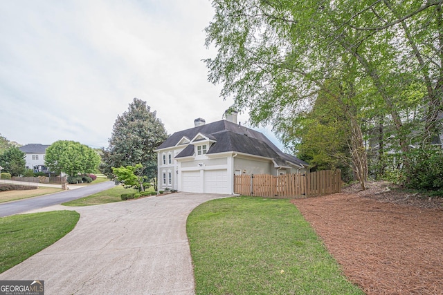 exterior space with stucco siding, fence, a front lawn, a chimney, and concrete driveway