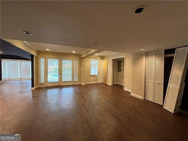 unfurnished living room featuring dark hardwood / wood-style flooring and french doors